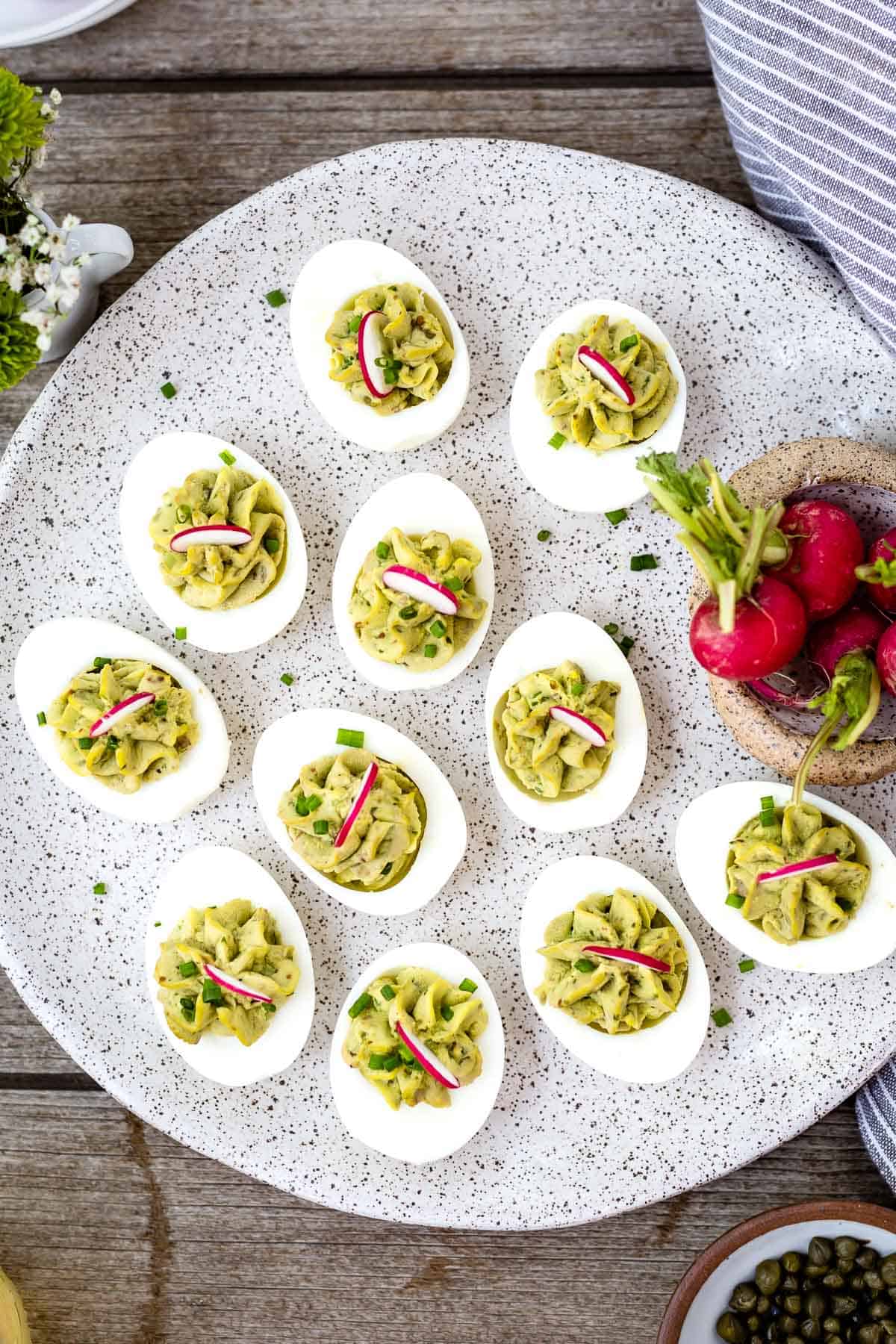 A plate filled with deviled eggs without mayo are photographed from the top view.
