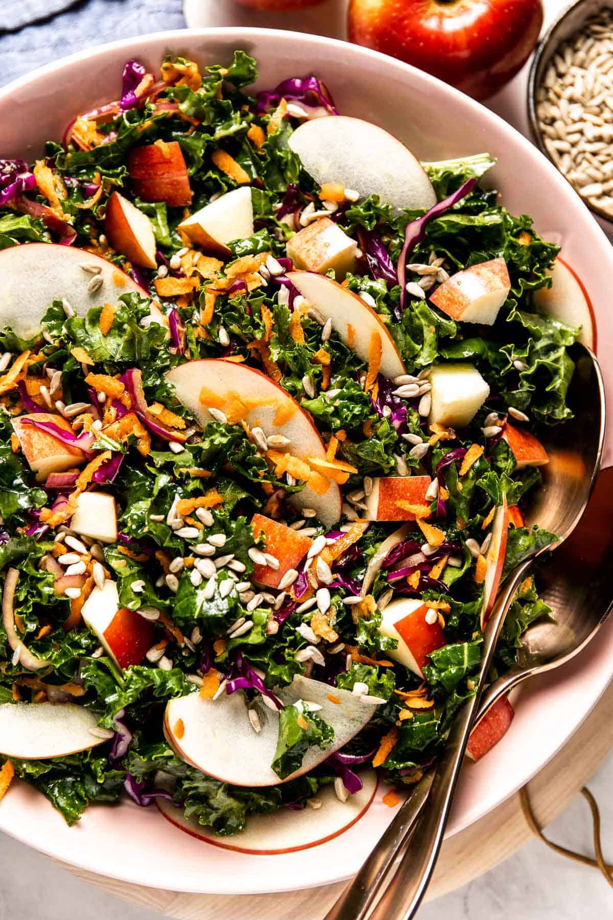 Kale and Apple Slaw in a bowl with two spoons on the side