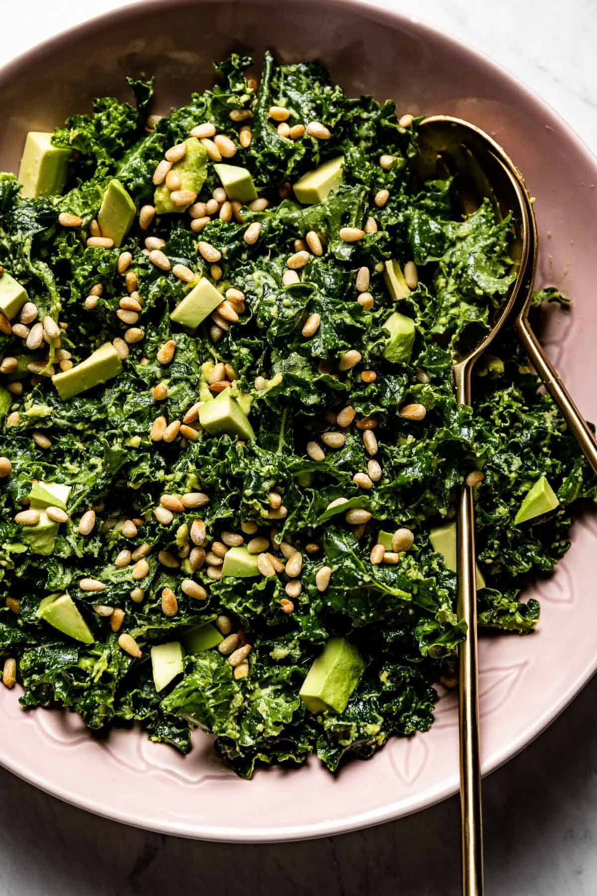 massaged kale salad with avocado in a bowl from the top view