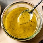 Maple Dijon Salad dressing in a spoon over a jar