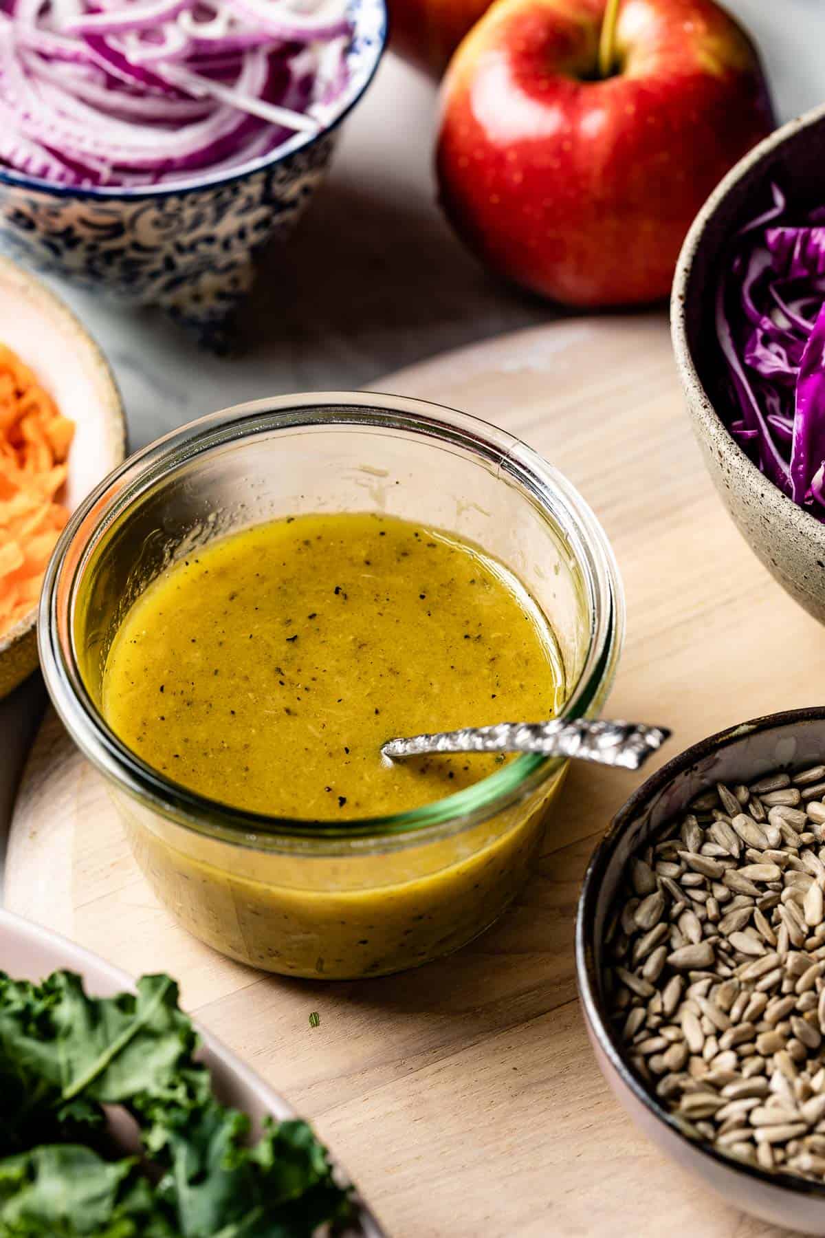 Maple Vinaigrette in a glass bowl with vegetables around it