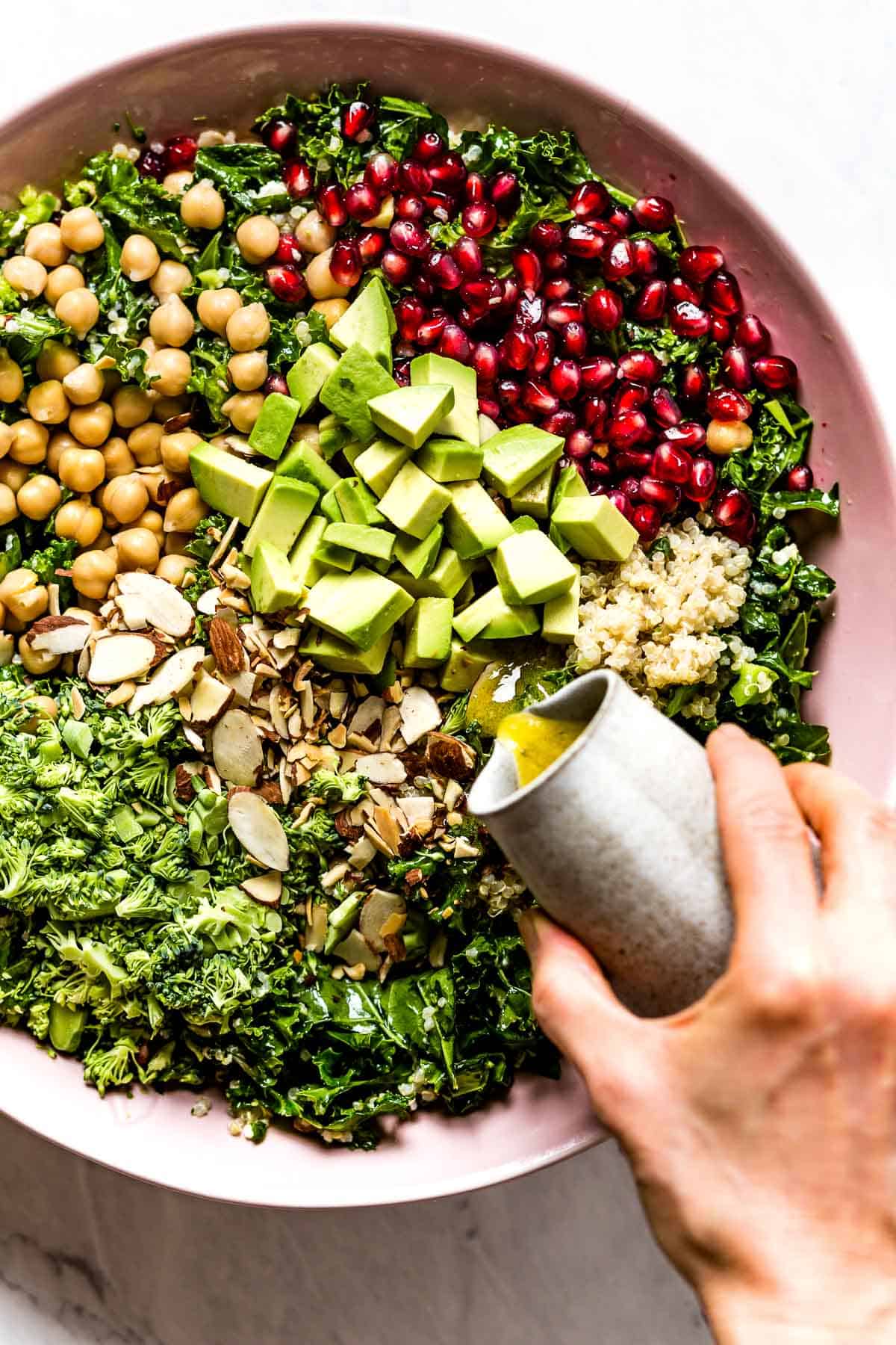 Kale Quinoa Salad being drizzled with the dressing