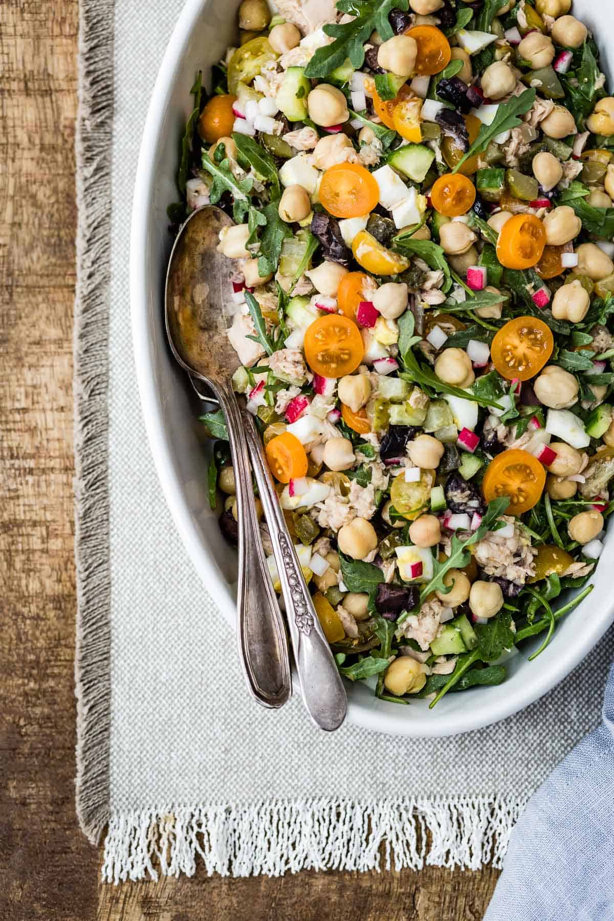 Chickpea Tuna Salad in an oval bowl with spoons on the side