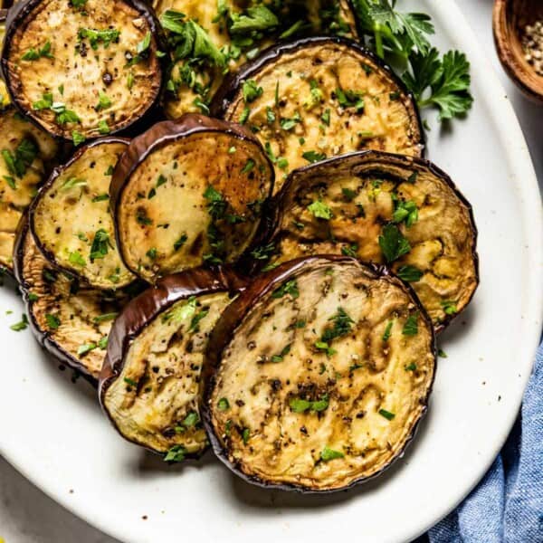 baked eggplant slices garnished with parsley on a plate