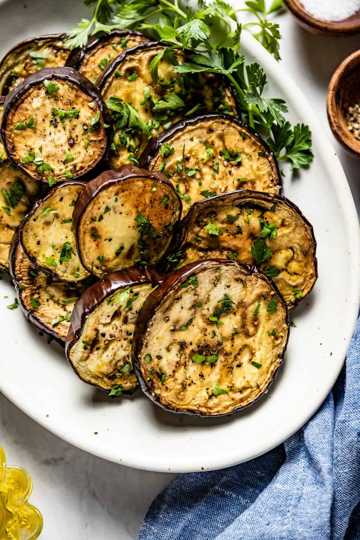 Baked Eggplant Slices garnished with fresh herbs on a plate