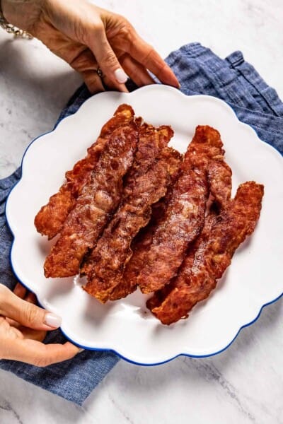 turkey bacon cooked in air fryer on a plate served by a person