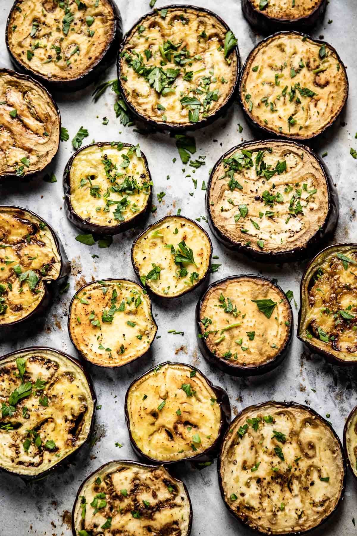 Baked aubergine slices on a sheet pan from the top view