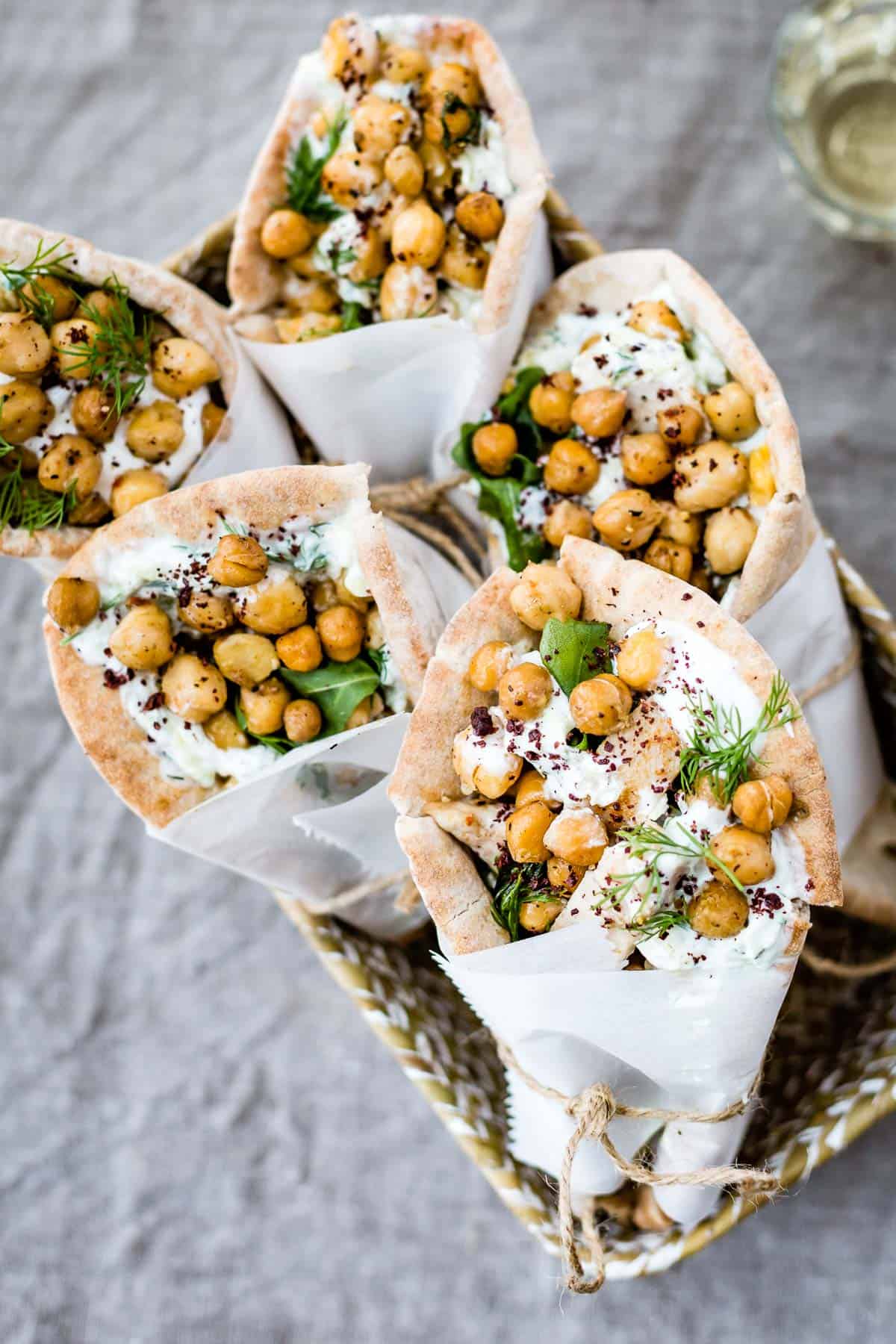 Greek chicken pita wraps with chickpeas rolled and placed in a container