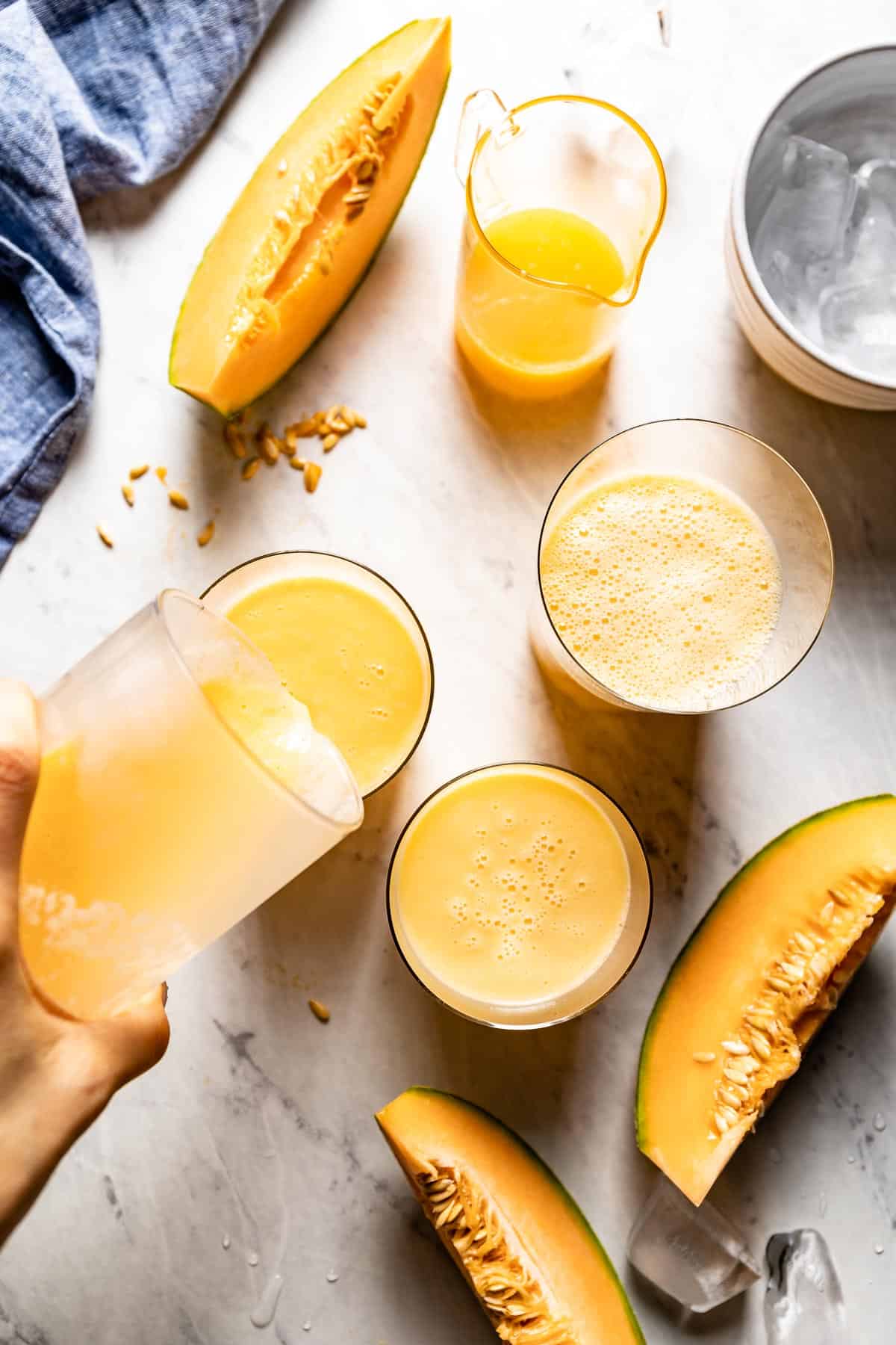 person pouring smoothie into a glass