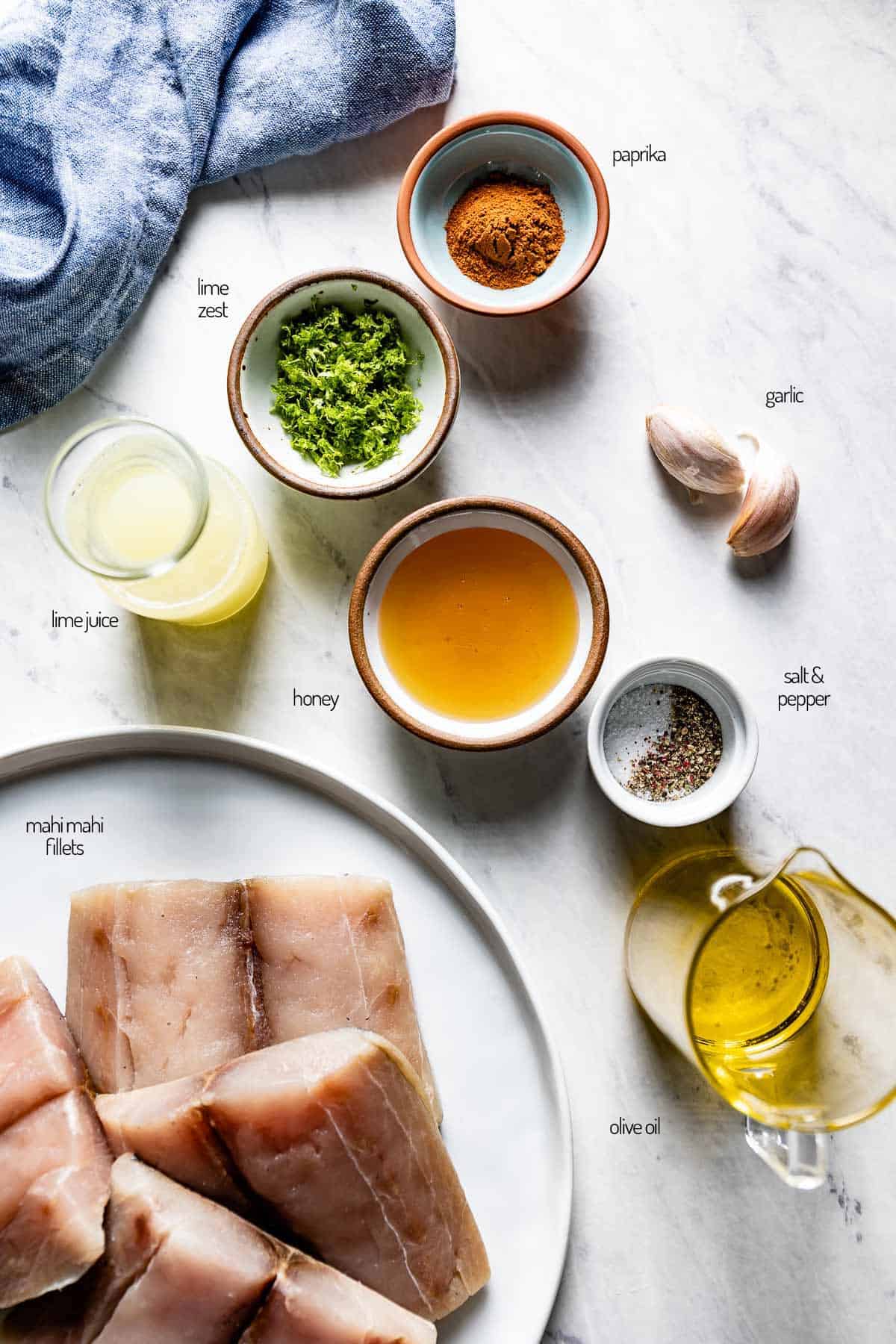 ingredients for the recipe are laid out on a white marble counter