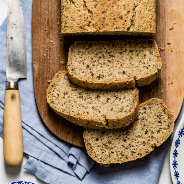 Quick almond flour bread sliced from the top view with cream cheese and a knife on the side.