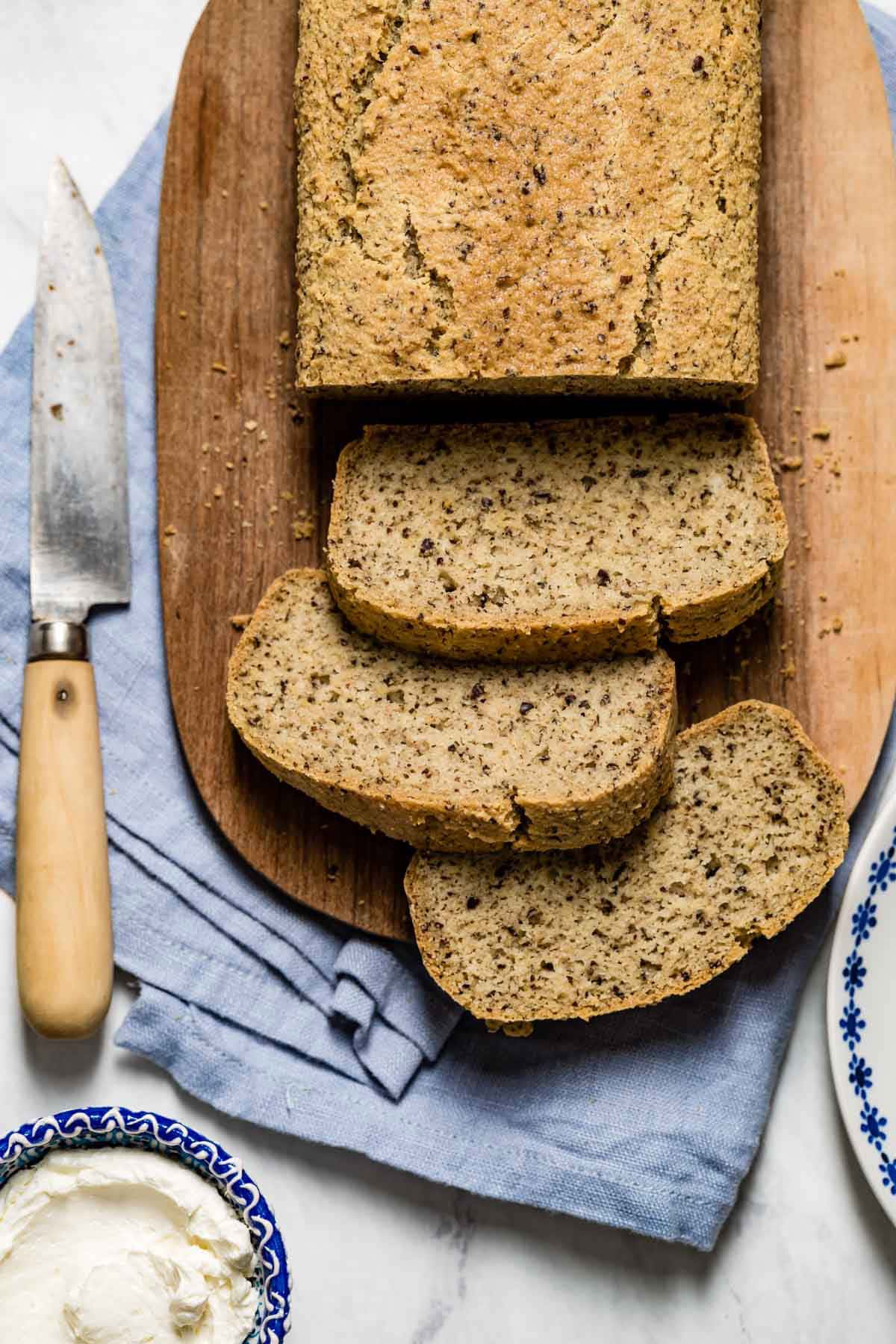 Quick almond flour bread sliced from the top view with cream cheese and a knife on the side.