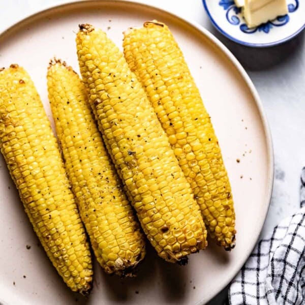 Air fryer corn on the cob on a plate from the top view