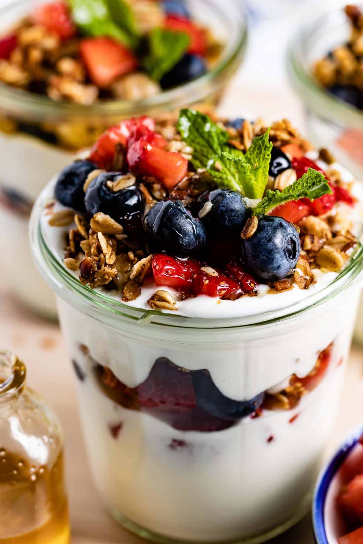 fruit and yogurt parfait garnished with mint from the front view