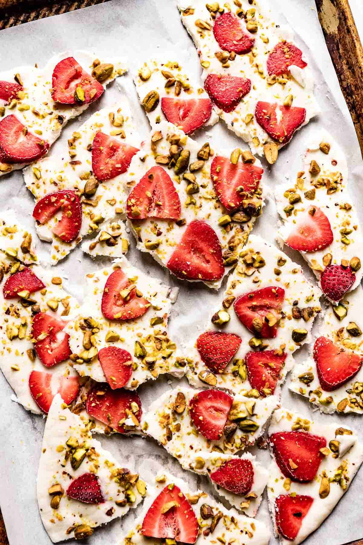 frozen yogurt bars with berries and nuts on a plate from the top view