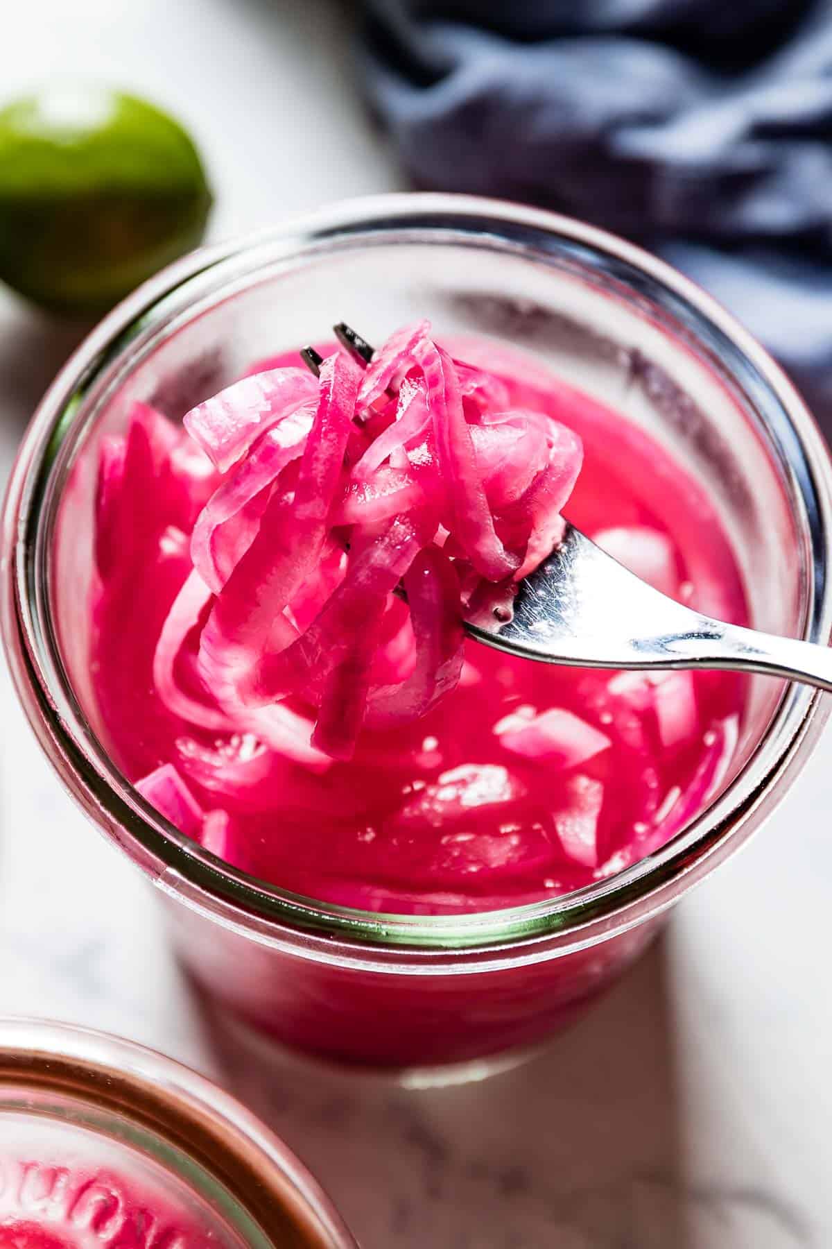 Mexican pickled red onions in a jar with a fork from the top view 
