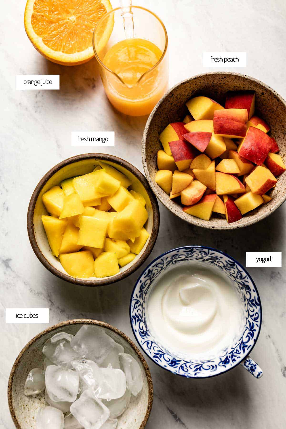 Ingredients for a mango peach smoothie in bowls from the top view. 