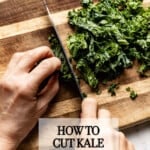 A person chopping kale on a cutting board from the top view.