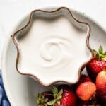 vanilla yogurt recipe in a bowl with strawberries on the side from top view