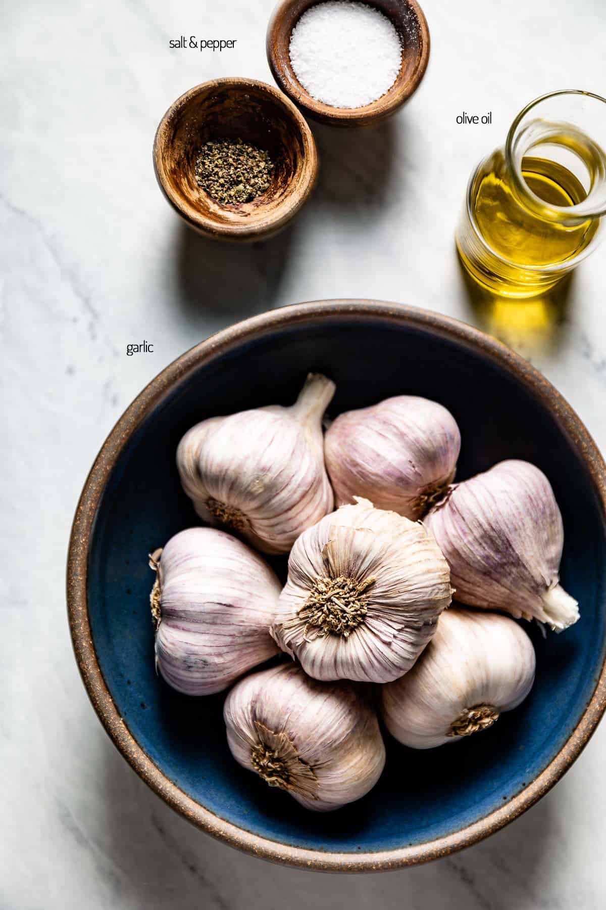 Ingredients for air fryer roasted garlic in bowls from the top view. 