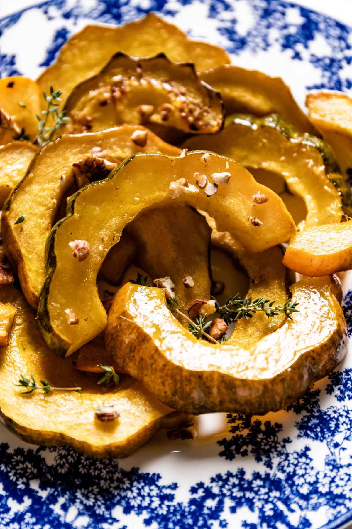 A plate of oven-roasted acorn squash slices from the top view.