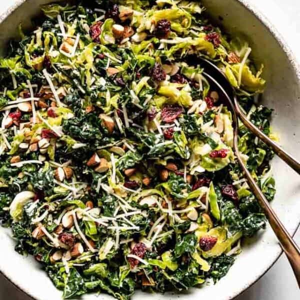 A bowl of Brussels Sprout and Kale Salad with two spoons on the side from the top view.