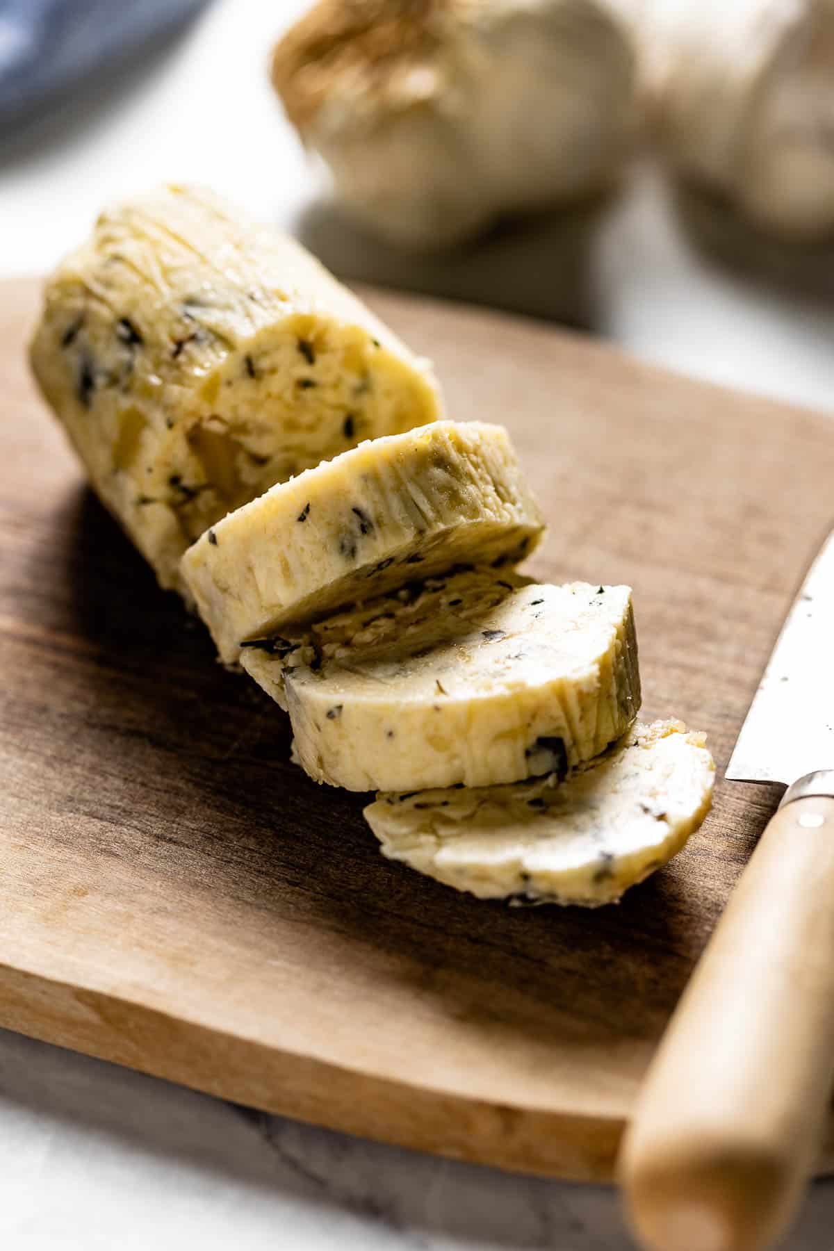 A log of garlic butter cut into slices from the side view. 