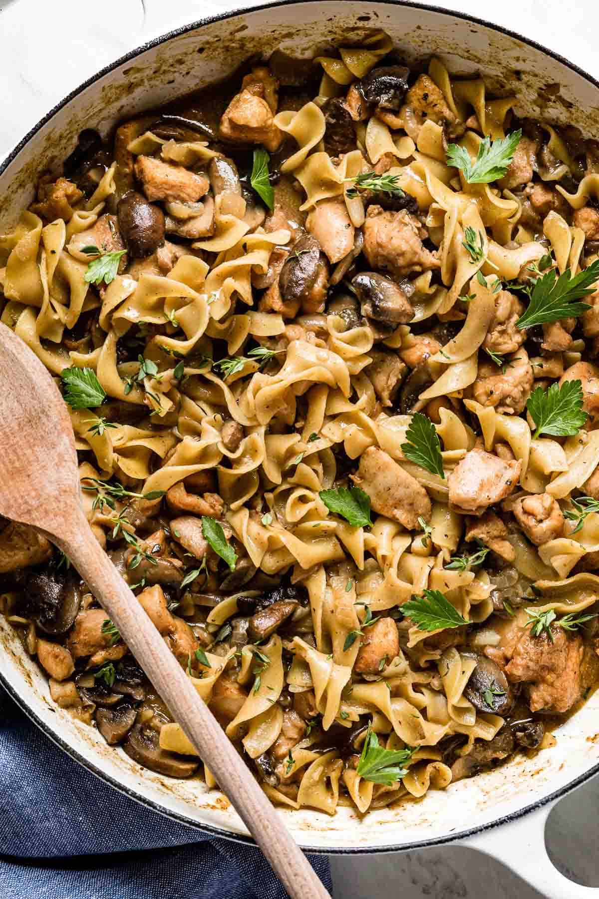 Chicken stroganoff with mushrooms and egg noodles in a large pan.
