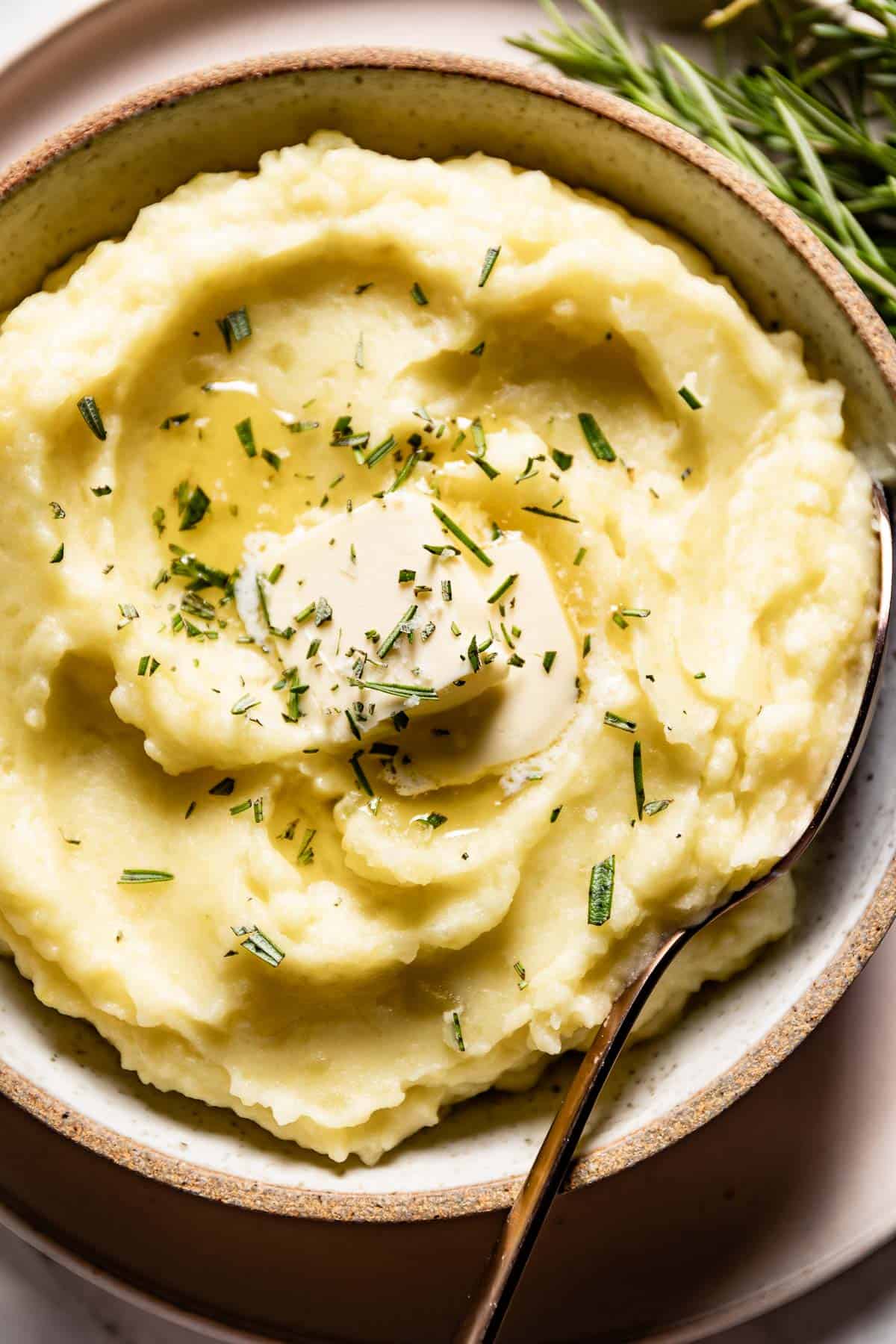 Mashed potatoes with garlic and rosemary in a bowl from the top view.