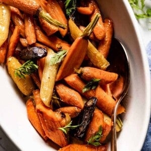 Glazed baked carrots in a serving bowl from the top view.