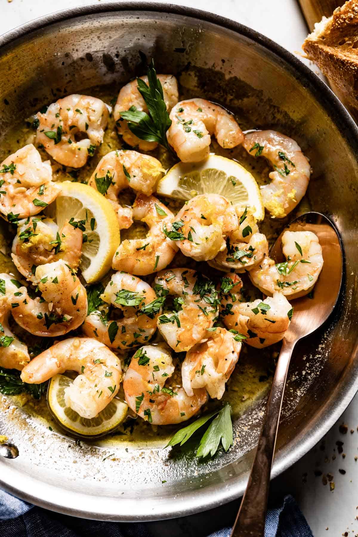 Garlic butter shrimp scampi without wine in a pan with a spoon from the top view.