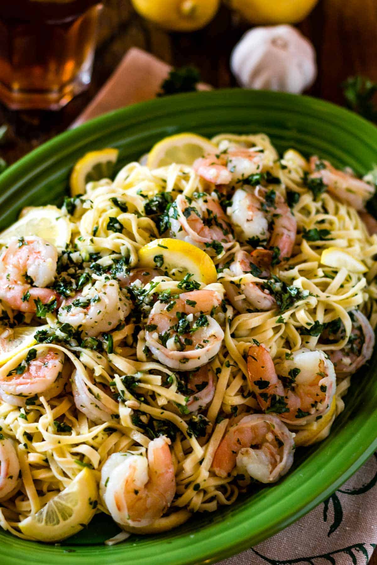 Shrimp with garlic scampi sauce and pasta in a bowl from the top view.