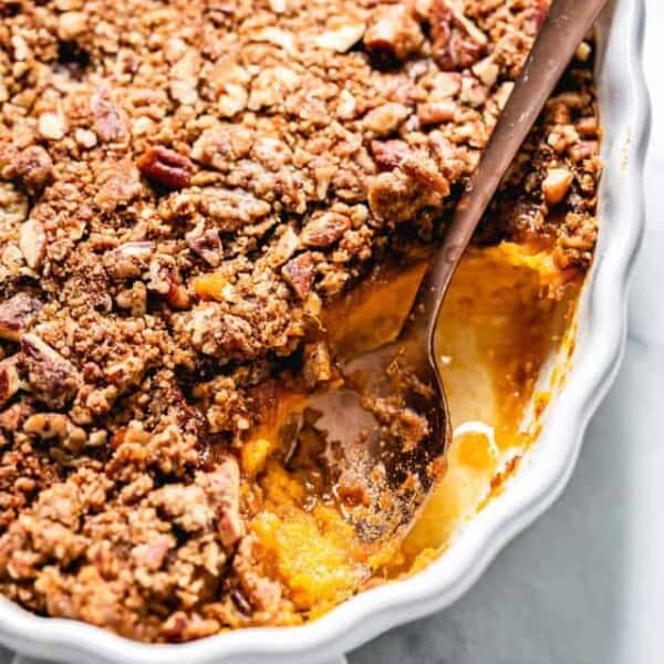 Sweet potato casserole from the front view with a spoon on the side.