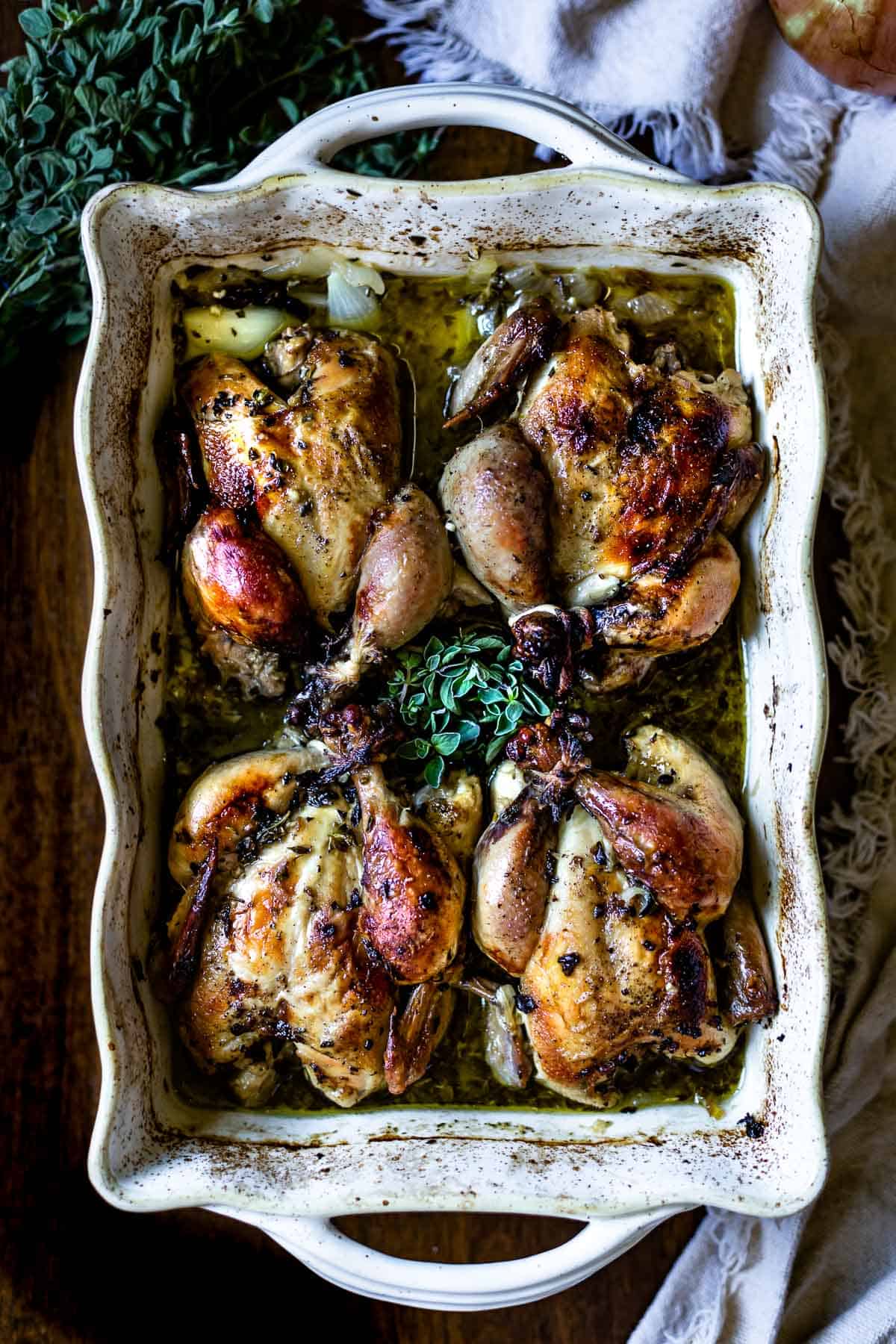 Roasted cornish hens in a casserole dish from the top view.