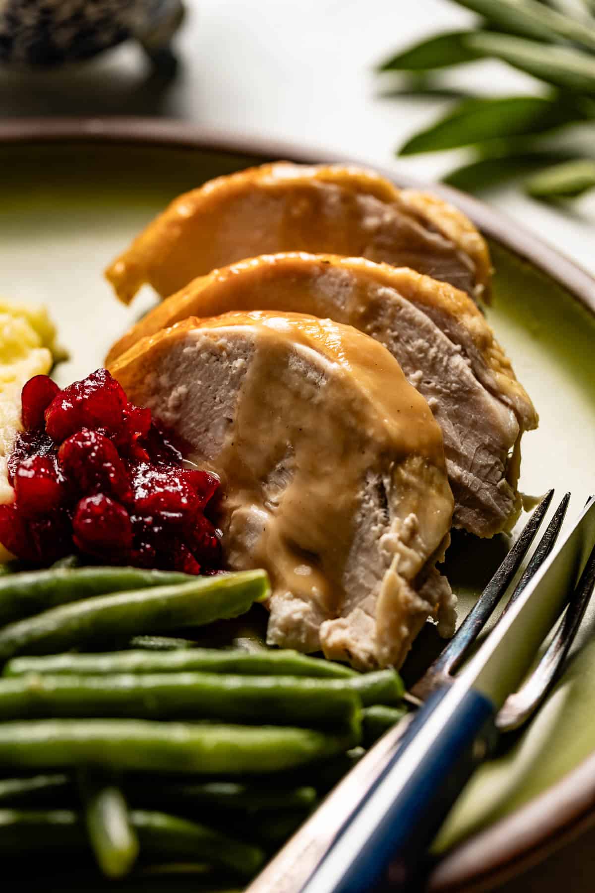 Roasted turkey breast drizzled with gravy as Friendsgiving dish idea.