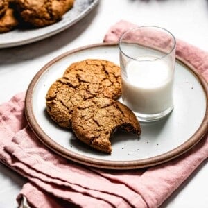 Gingerbread cookies on a plate with a glass of milk.