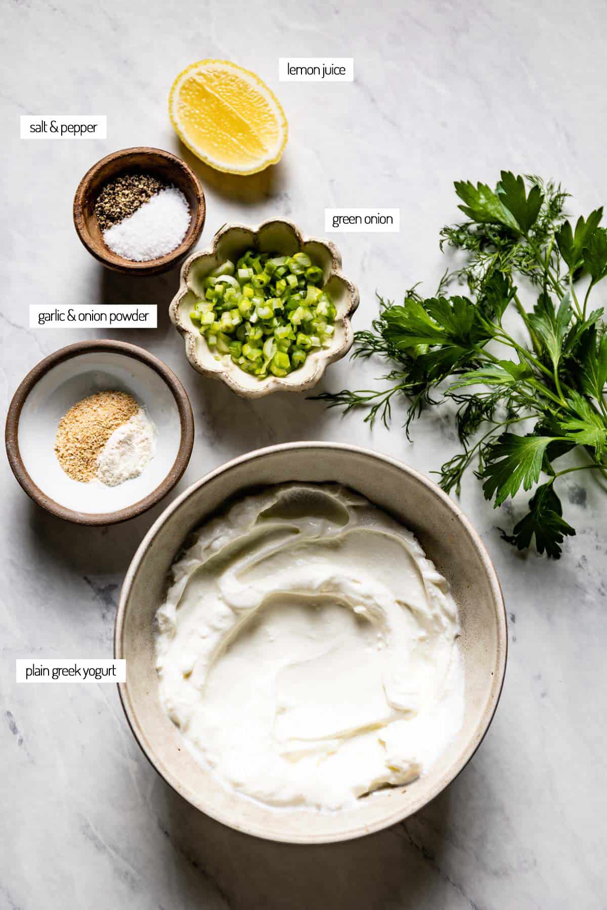 Ingredients for homemade greek yogurt ranch in bowls from the top view.