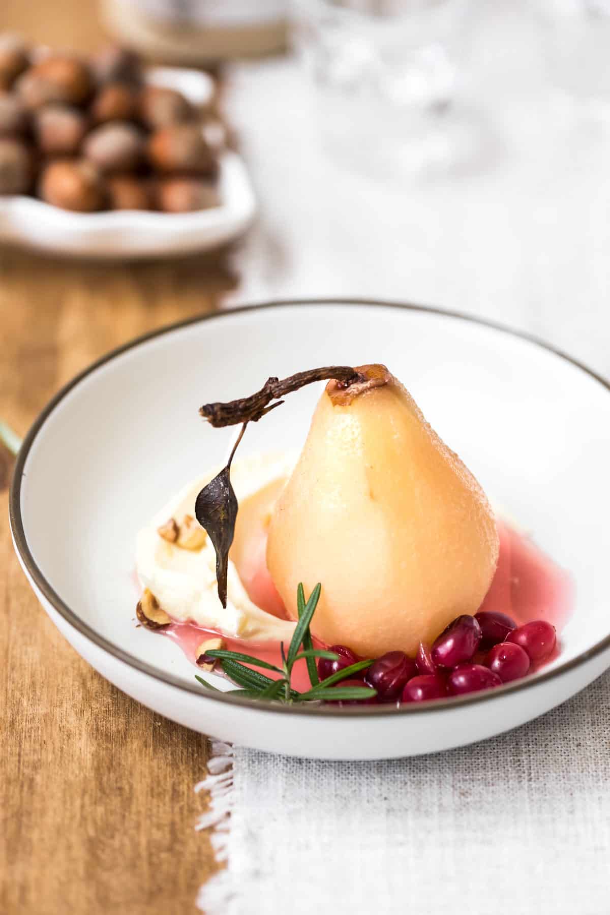 Cranberry poached pear on a plate from the front view.