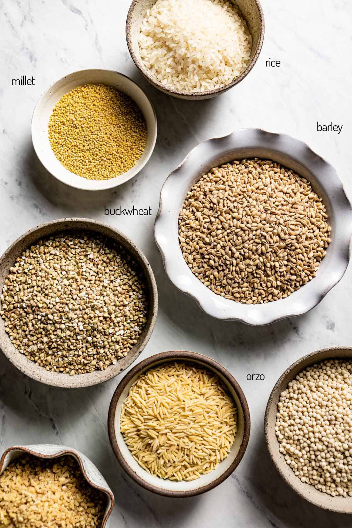 Grains considered as bulgar wheat alternatives in small bowls from the top view.