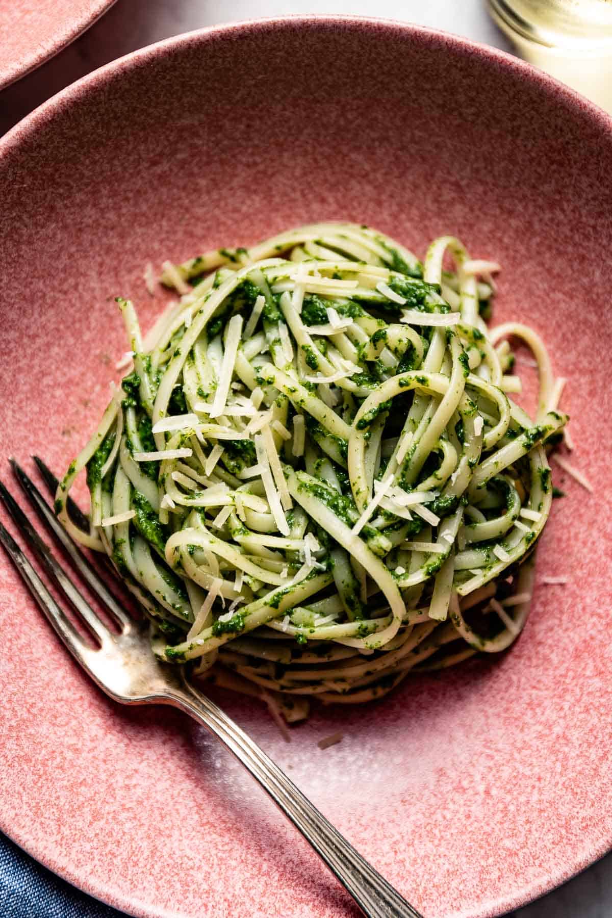 Green noodle pasta in a bowl with a fork from the top view.