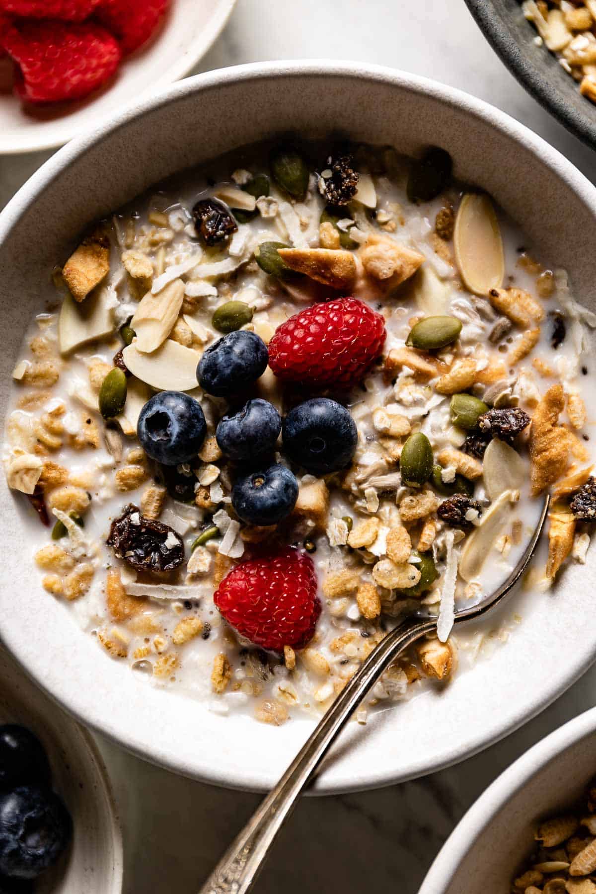 Fruit muesli in a bowl with milk and a spoon from the top view.