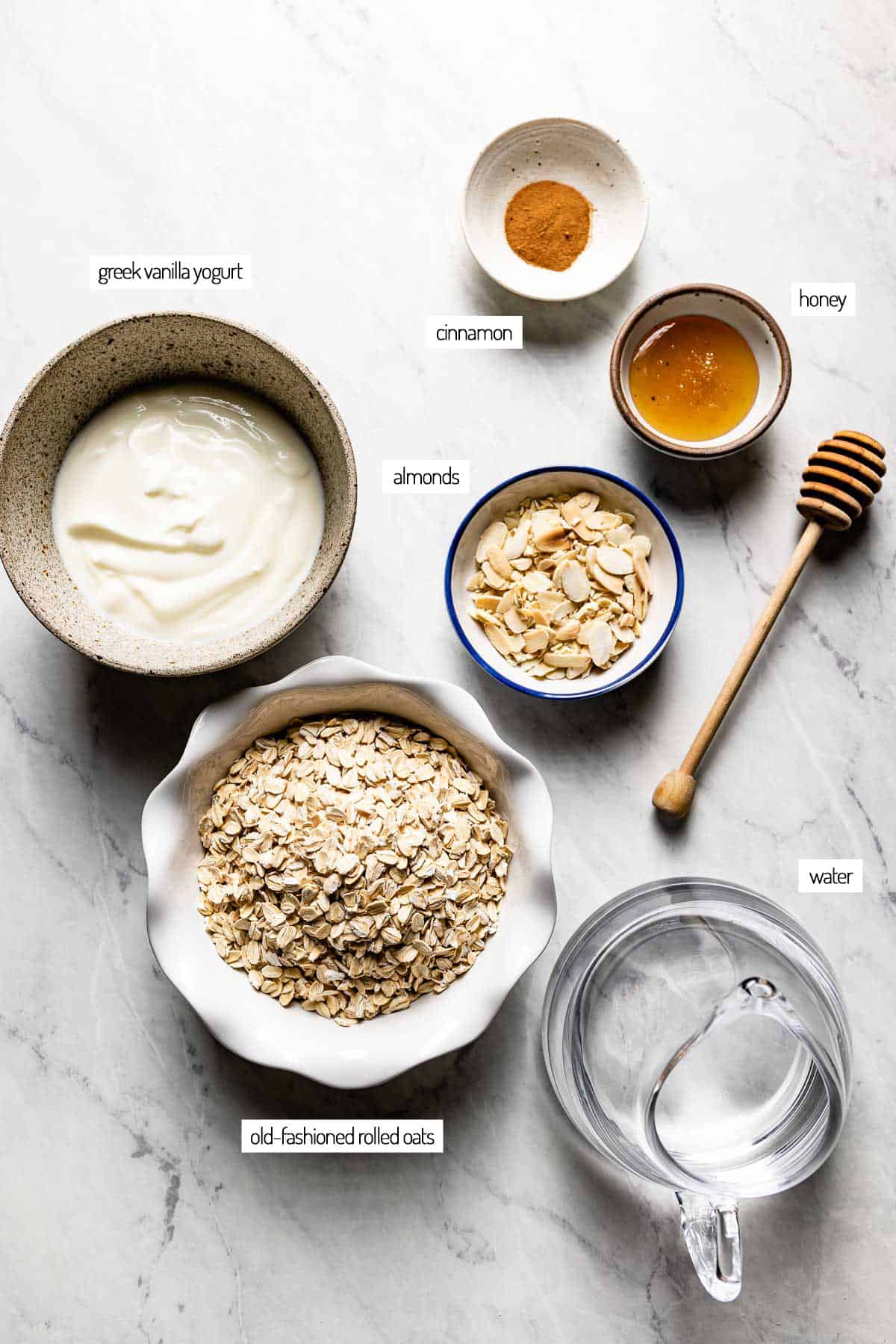 Ingredients for a greek yogurt and oatmeal recipe in bowls from the top view.