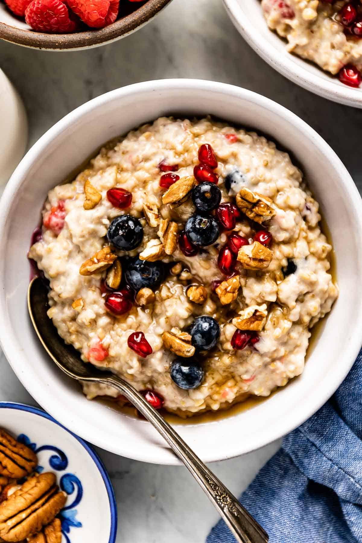 A bowl of slow cooker steel cut oatmeal garnished with fruit and nuts.