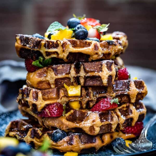 Brioche waffles layered with fruit from the front view.