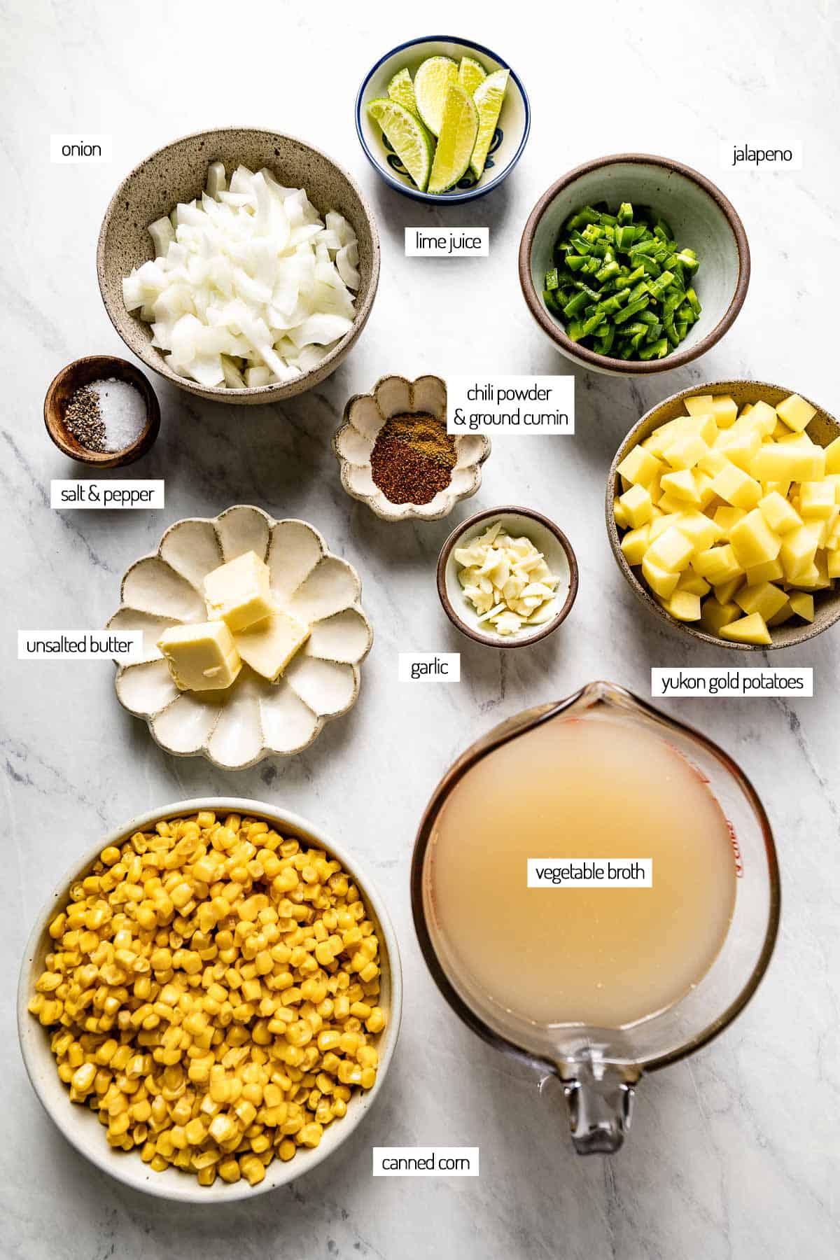 Ingredients for a soup made with corn and potatoes in bowls shown from the top view.