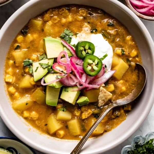 A soup with corn and potatoes in a bowl from the top view.