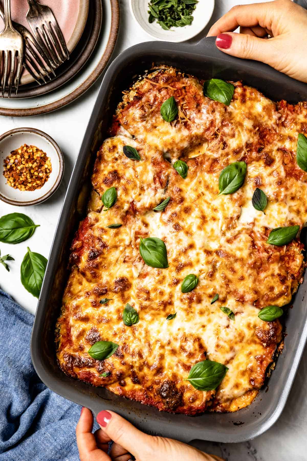 Easy baked eggplant parmesan in a casserole dish from the top view.