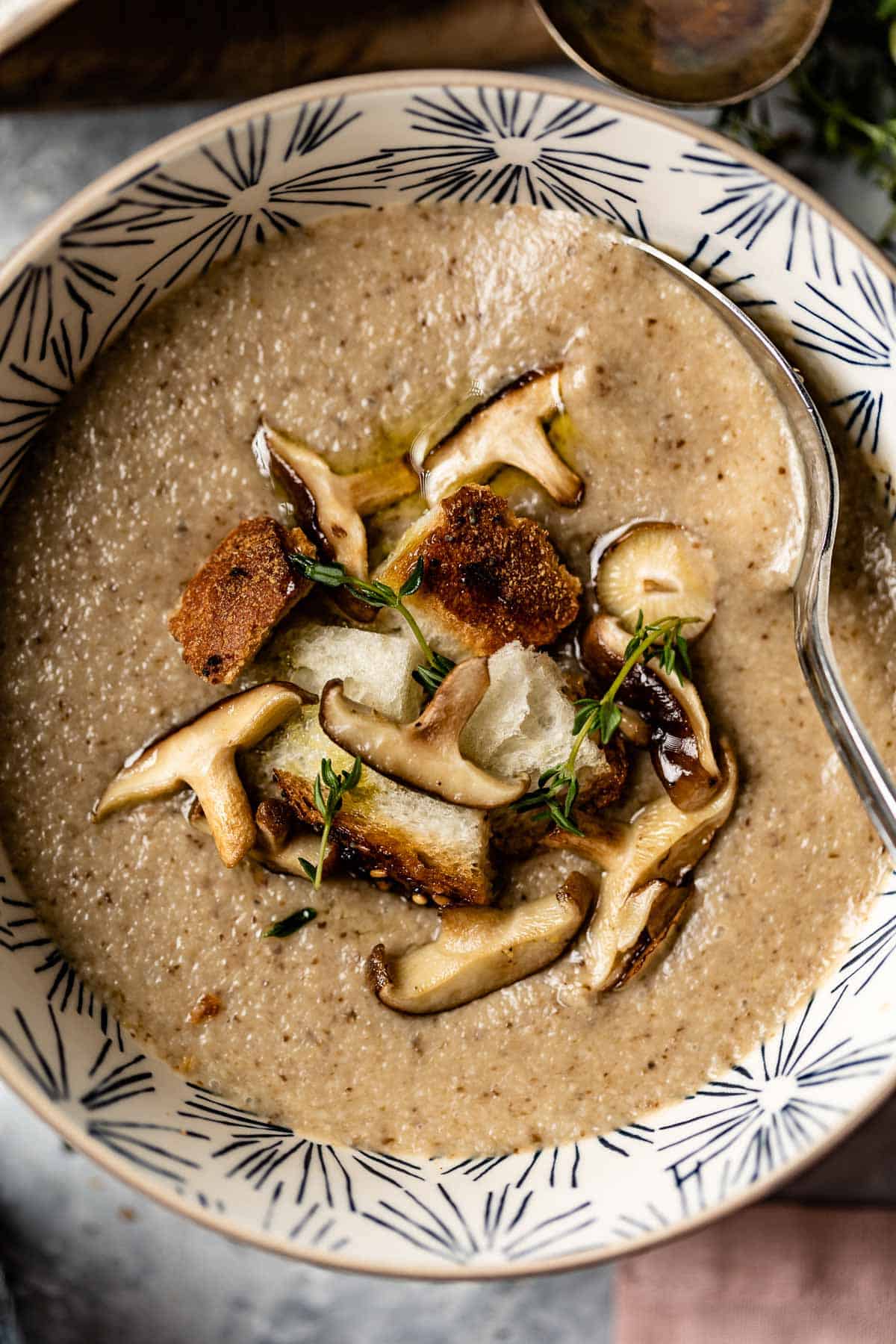 A creamy soup made with mushrooms in a bowl from the top view.