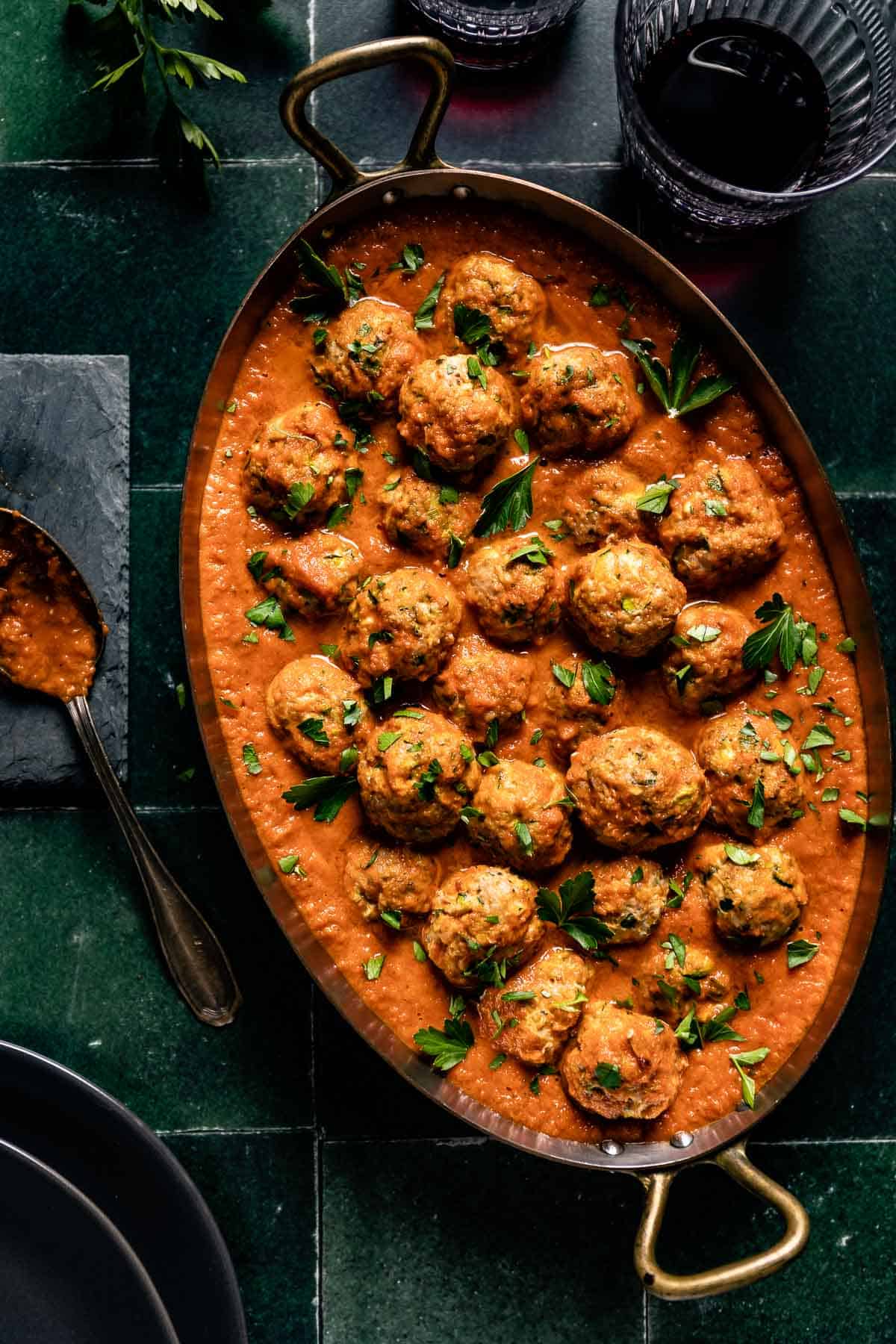 A large pan with tomato sauce and meatballs shown from the top view.