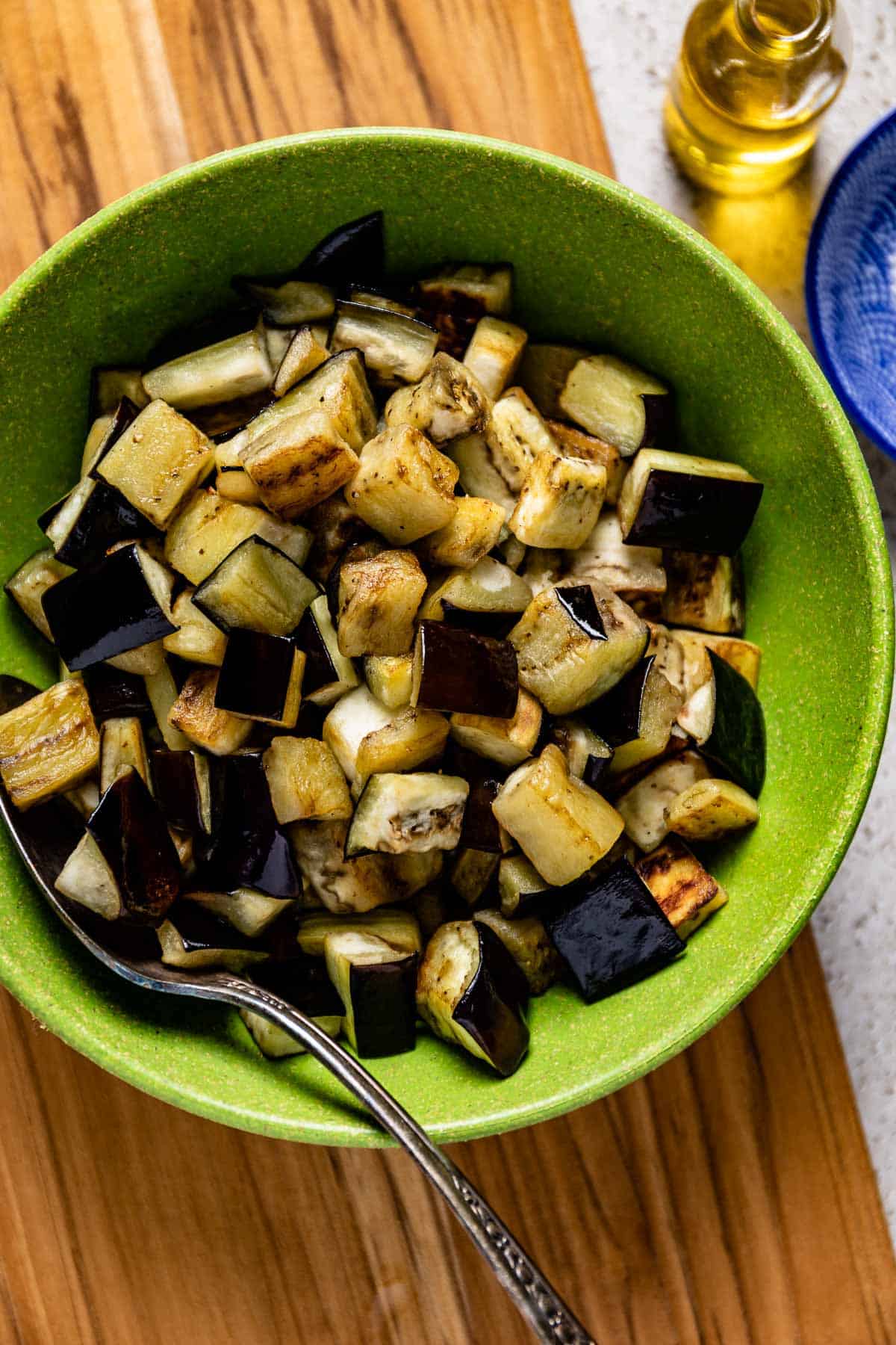 Sauteed eggplant cubes in a plate from the top view.